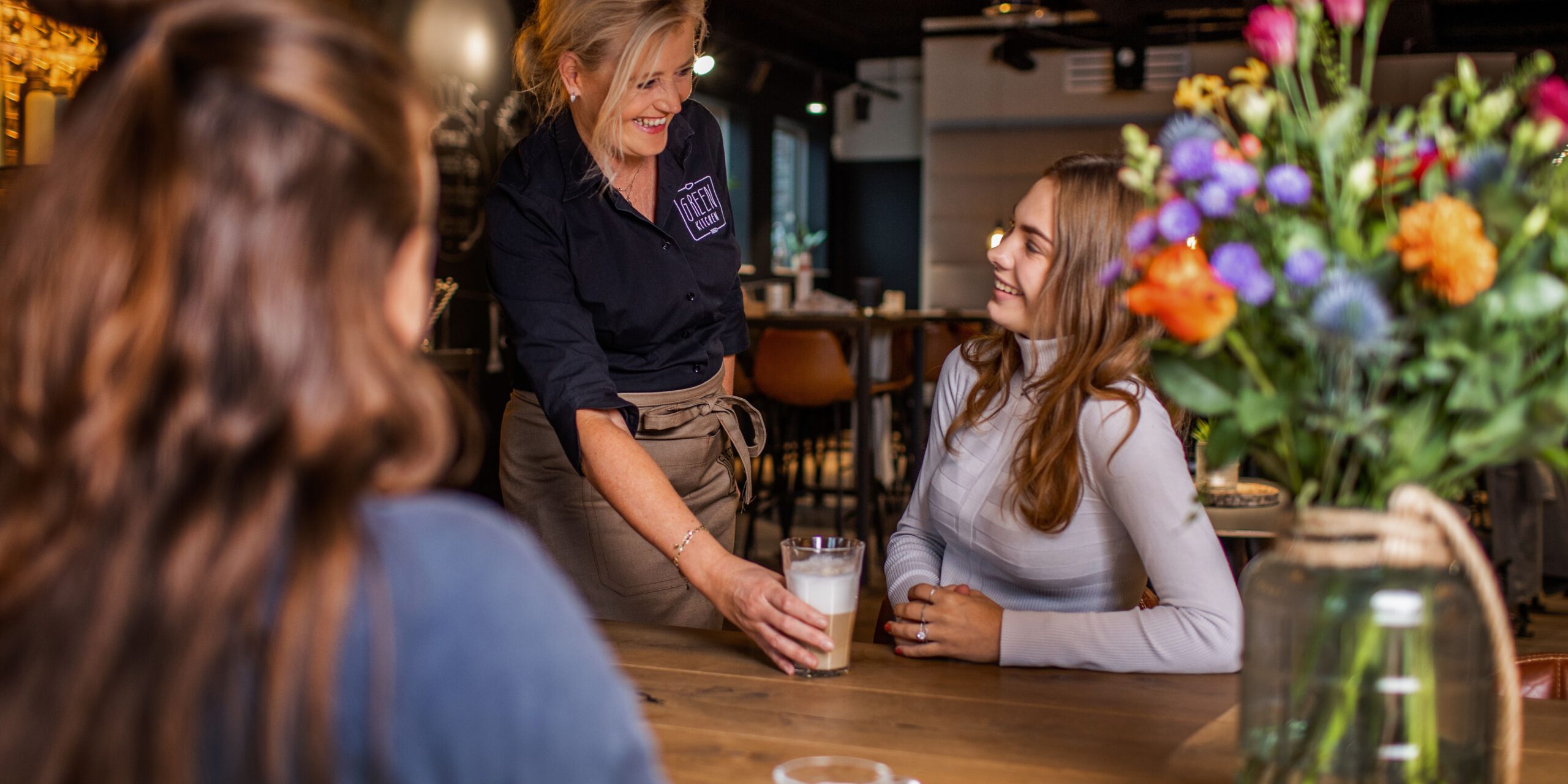 Cateringmedewerker geeft gast koffie