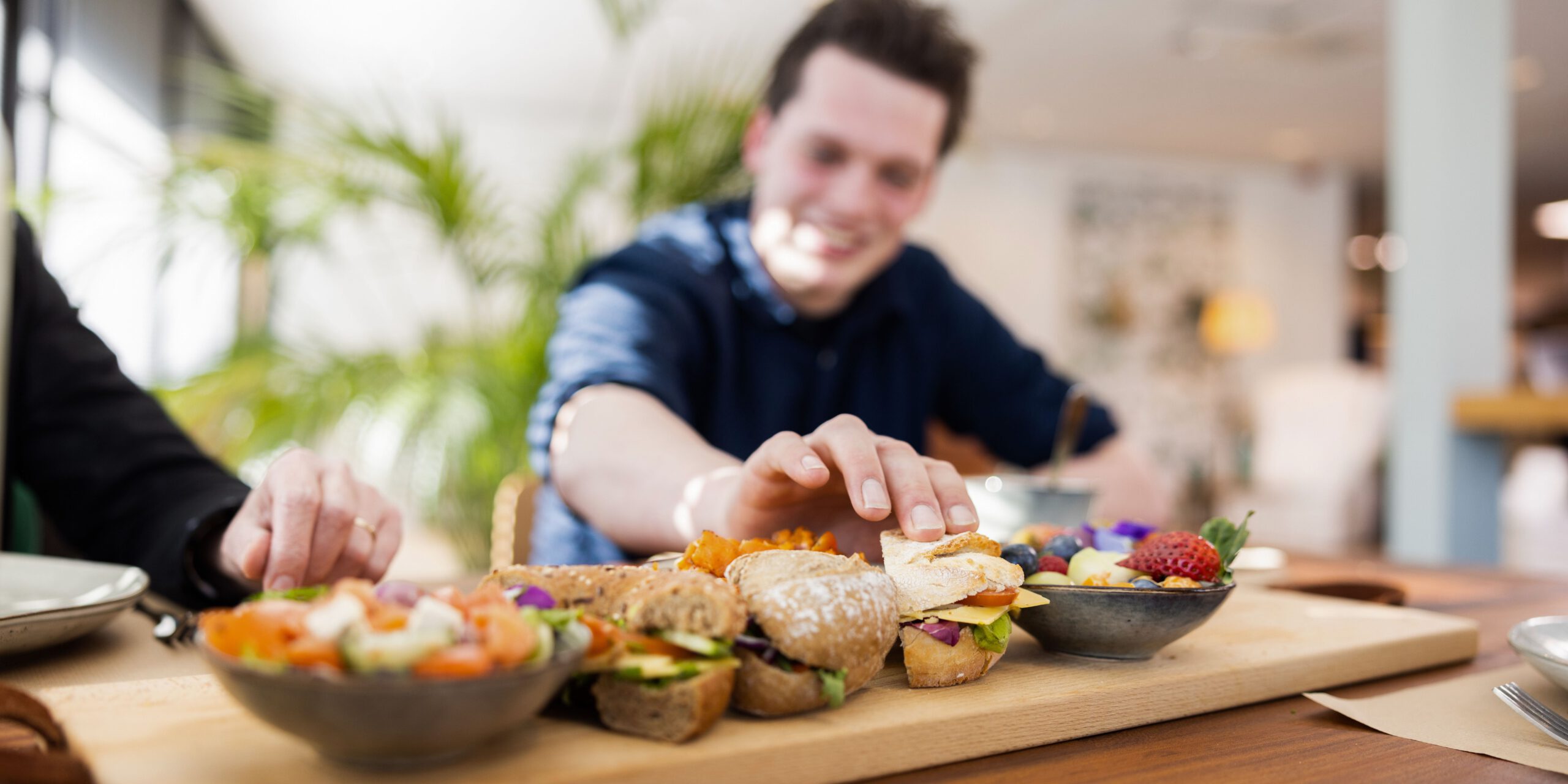 Gast met een schaal banqueting broodjes