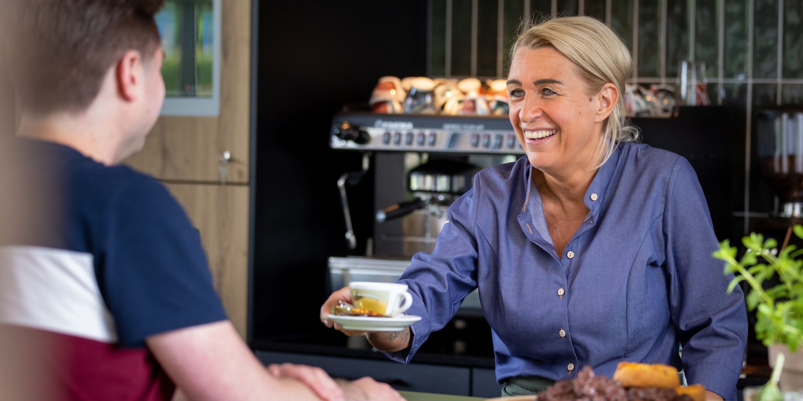 Barista geeft gast een kop koffie